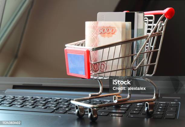 Shopping Trolley With Money Russian Rubles And Credit Cards On Opened Laptop Stock Photo - Download Image Now