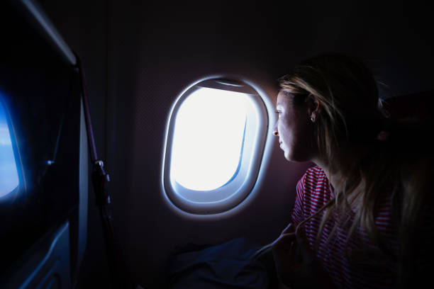 istock Blonde woman sitting in front of window on plane 1124384352