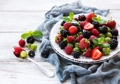 Plate with summer berries on a old wooden table