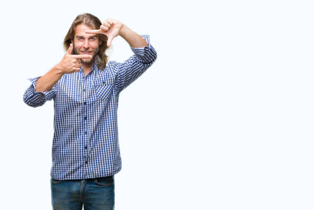 istock Young handsome man with long hair over isolated background smiling making frame with hands and fingers with happy face. Creativity and photography concept. 1124390337