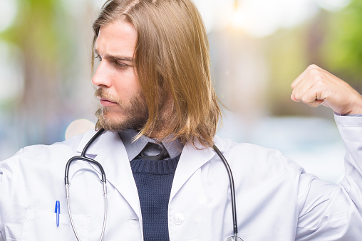 Young Handsome Doctor Man With Long Hair Over Isolated Background Showing Arms Muscles Smiling Proud Fitness Concept Stock Photo - Download Image Now - iStock Young Handsome Doctor Man With Long Hair Over Isolated Background Showing Arms Muscles Smiling Proud Fitness Concept Stock Photo - Download Image Now - iStock