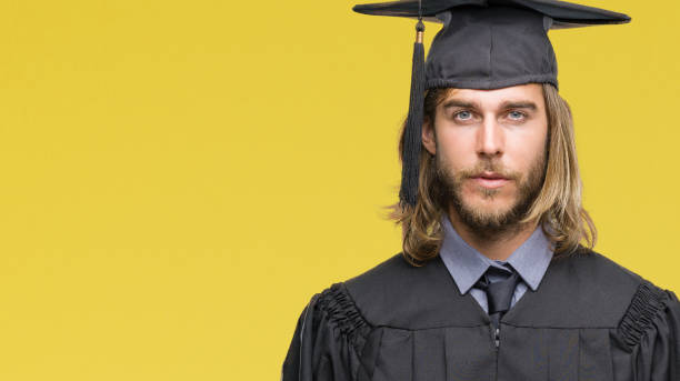istock Young handsome graduated man with long hair over isolated background with serious expression on face. Simple and natural looking at the camera. 1124391649