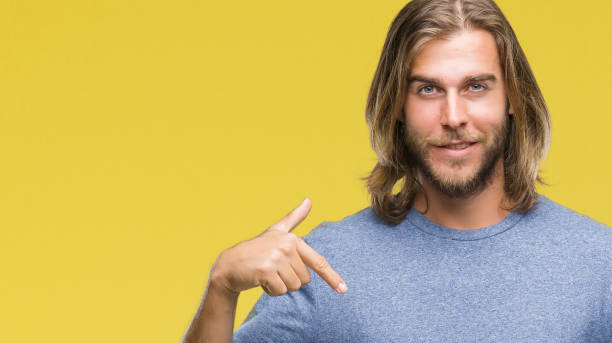 istock Young handsome man with long hair over isolated background looking confident with smile on face, pointing oneself with fingers proud and happy. 1124391826