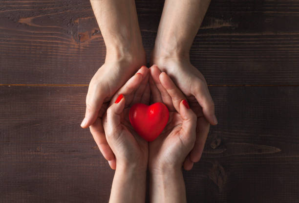 istock Man and woman holding red heart 1124393011