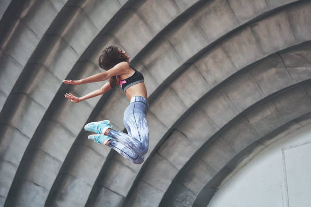 Photo of a beautiful woman doing parkour Photo of a beautiful woman doing parkour. free running stock pictures, royalty-free photos & images