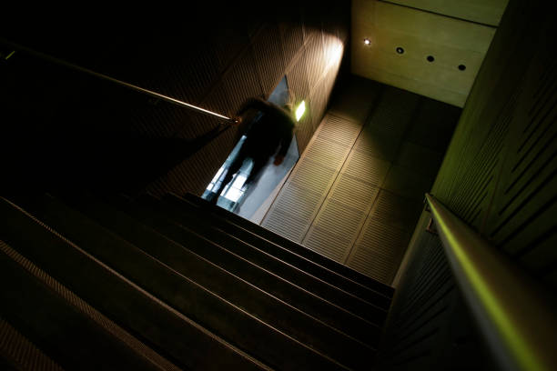 istock Blurred silhouette of unrecognizable man going upstairs from underground. From darkness to light. Overcoming adversity. Abstract photo on the subject of architecture, urban lifestyle or social issues. 1124398766