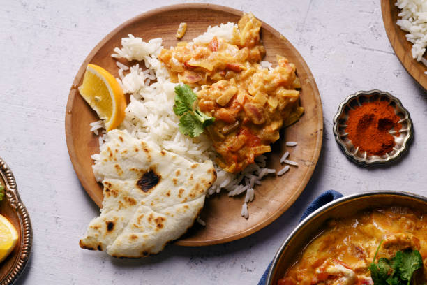istock Indian cuisine: chicken tikka masala with rice and naan bread and spices. 1124398870