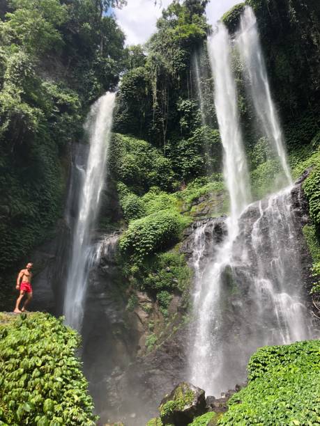 istock Man under the Sekumpul waterfalls in Bali 1124400540