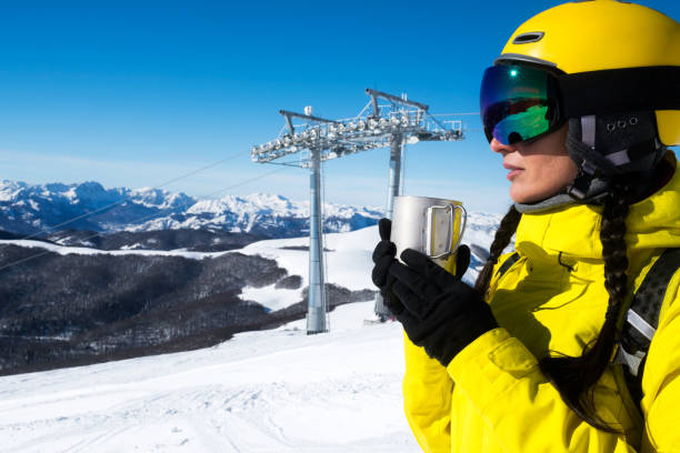 istock Female skier enjoying a hot beverage from a cup while resting from a ski touring challenge. 1124402527