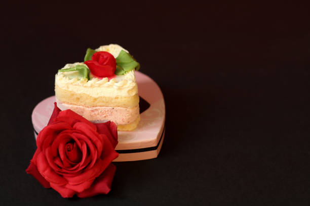 Heart shape cake, perfect for Valentine's or anniversary, red rose, black background, selective focus, free copy space