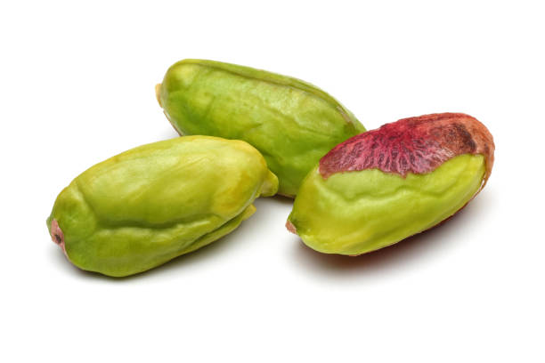 Peeled pistachio nuts on white background