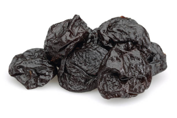 istock Dried black plums on white background 1124405116
