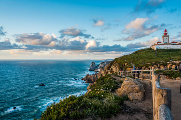 the atlantic coast north of cabo da roca with its lighthouse at sunset - direction sea lighthouse landscape imagens e fotografias de stock