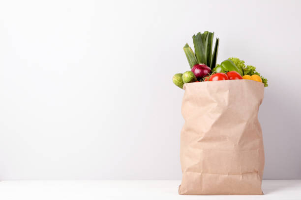 bolso de compras de supermercado con alimentos sobre fondo gris - paper bag fotos fotografías e imágenes de stock