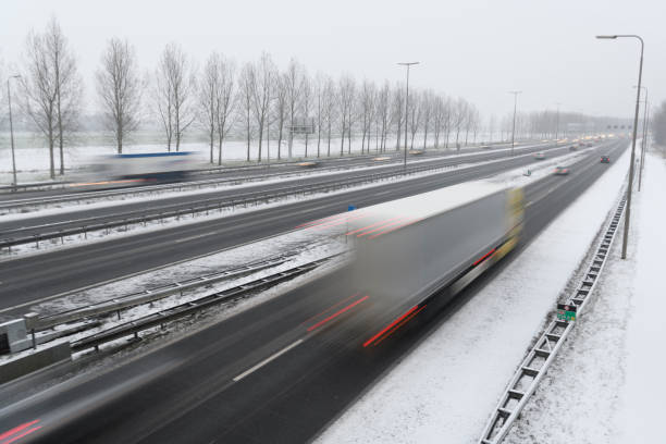 istock Moving traffic on a highway during a snow blizzard in winter 1124405930