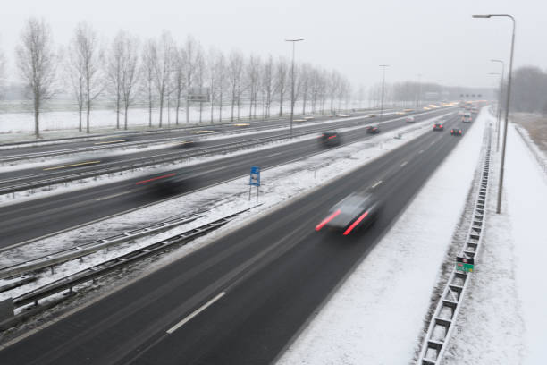 istock Moving traffic on a highway during a snow blizzard in winter 1124407380