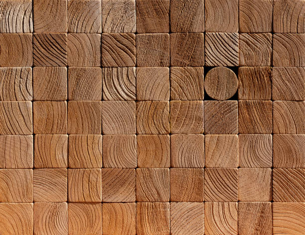 istock Many wood square, weathered, grain visible wooden blocks stacked up with one different round block within the stack standing out from the crowd within the background. 1124408056