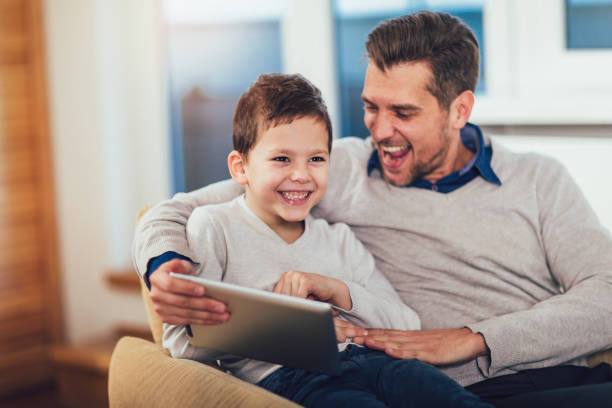 istock Father and son playing on a tablet at home, having fun. 1124409183