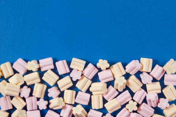 istock Soft Pink and Yellow Marshmallows on Blue Background 1124410841