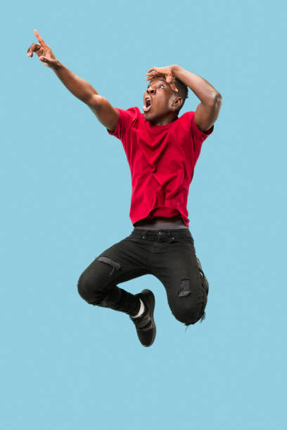 istock Freedom in moving and forward motion. The happy surprised young afro man jumping 1124411547