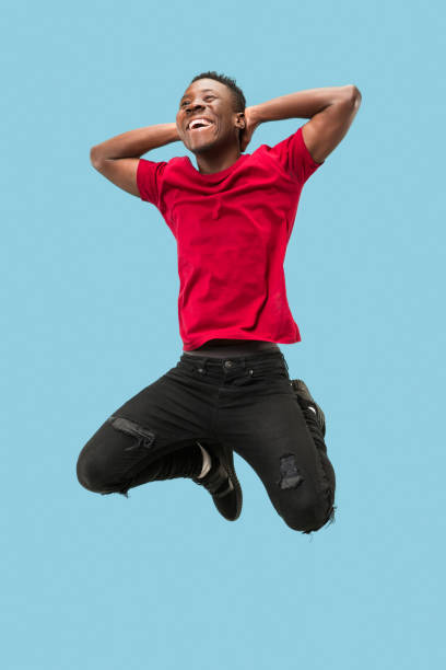 istock Freedom in moving and forward motion. The happy surprised young afro man jumping 1124411548