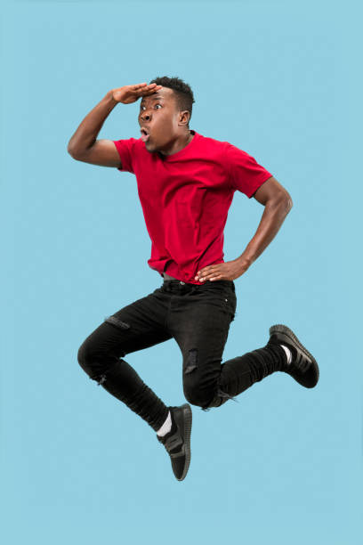 istock Freedom in moving and forward motion. The happy surprised young afro man jumping 1124411552