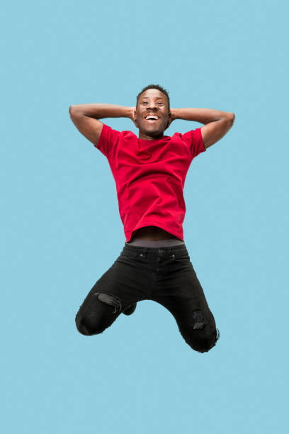 istock Freedom in moving and forward motion. The happy surprised young afro man jumping 1124411555