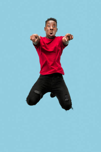 istock Freedom in moving and forward motion. The happy surprised young afro man jumping 1124411567