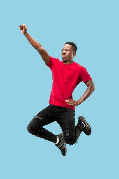 istock Freedom in moving and forward motion. The happy surprised young afro man jumping 1124411621