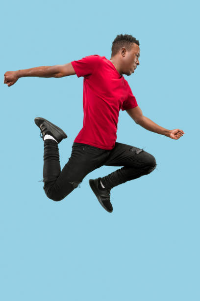 istock Freedom in moving and forward motion. The happy surprised young afro man jumping 1124411630