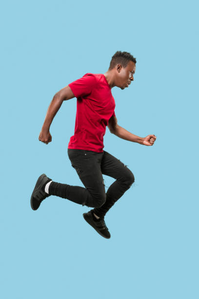 istock Freedom in moving and forward motion. The happy surprised young afro man jumping 1124411635