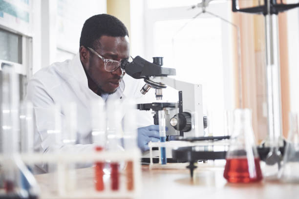 istock The scientist works with a microscope in a laboratory conducting experiments and formulas. 1124414588