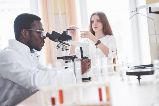 istock The scientist works with a microscope in a laboratory conducting experiments and formulas. 1124414764