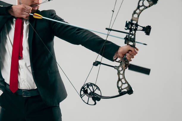 istock Businessman aiming at target with bow and arrow, isolated on white background 1124415507