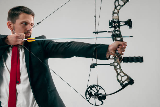 istock Businessman aiming at target with bow and arrow, isolated on white background 1124415511