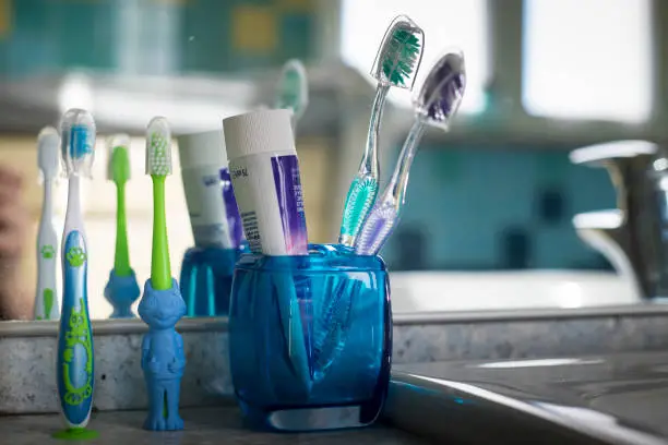 Photo of family toothbrushes in bathroom.