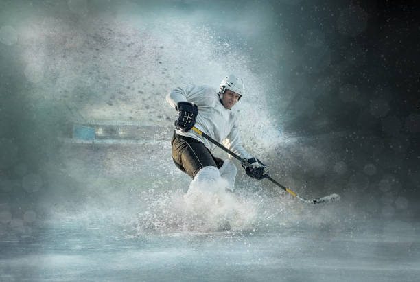 Caucasian ice hockey Players in dynamic action in a professional sport game play in hockey under stadium lights. Caucasian ice hockey Players in dynamic action in a professional sport game play in hockey under stadium lights. ice hockey stock pictures, royalty-free photos & images