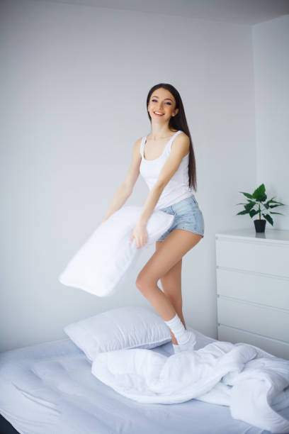 istock Happy girl jumping and having fun in bed 1124416473