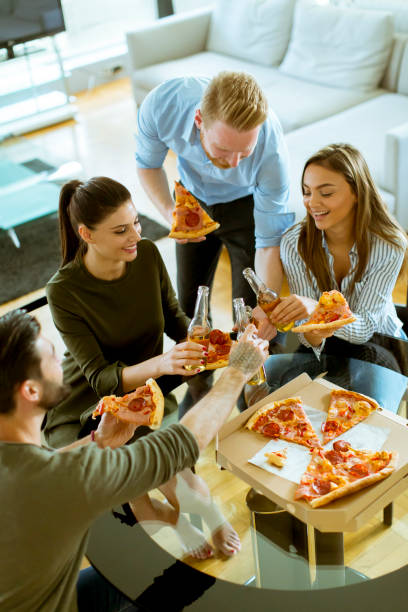 istock Young people eating pizza and drinking cider in the modern interior 1124416759