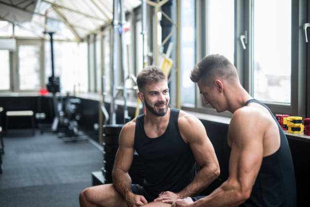 istock Two friends taking break from working out and talking in a gym 1124418199