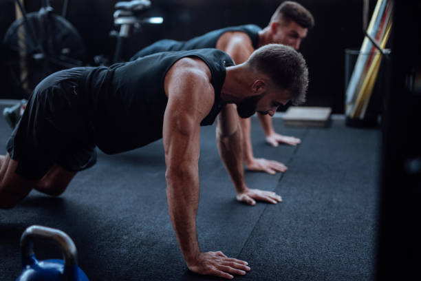 istock Two man doing push ups in the gym 1124418426