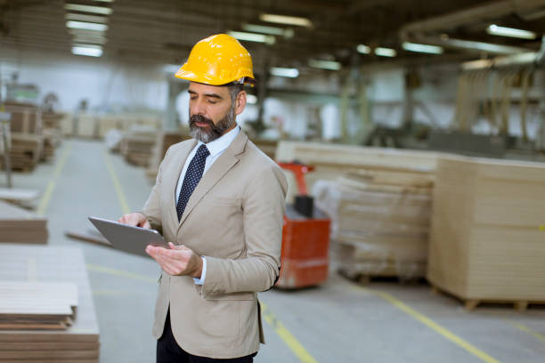 istock Middle-aged businessman with digital tablet in factory 1124418758