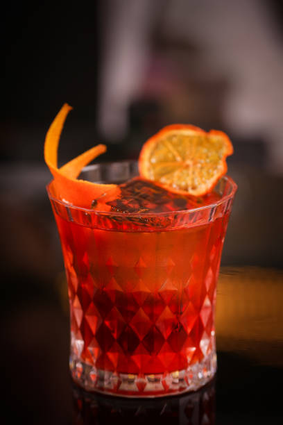 istock Orange cocktail in retro glass on black background 1124418939