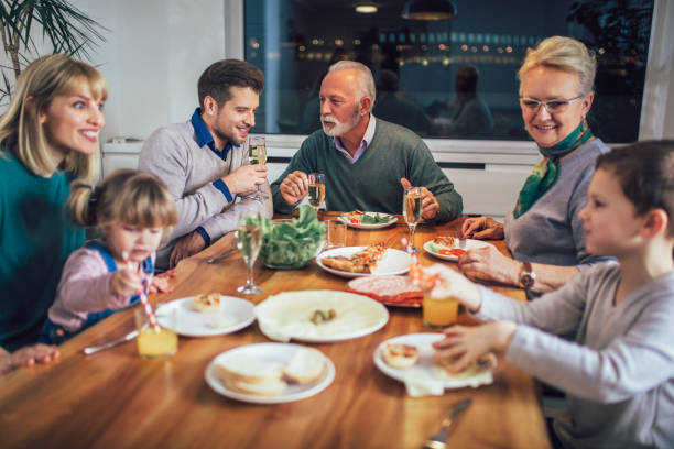 istock Multi generation family enjoying meal around table at home 1124418968