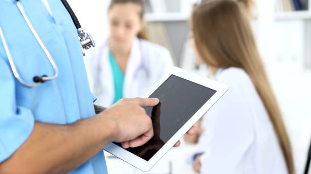 istock Surgeon doctor using tablet computer, close-up of hands at touch pad screen. 1124419039
