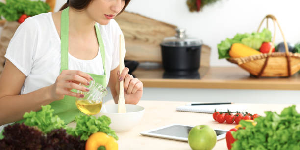 istock Beautiful Hispanic woman cooking while using tablet computer in kitchen. Housewife found new recipe for dinner or breakfast. 1124419149