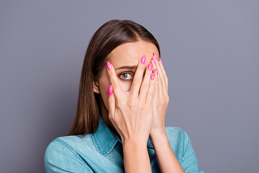 Close up studio photo portrait of sad upset unhappy afraid scared with brown hairstyle cute shy lady people person closing face with palms isolated on gray background