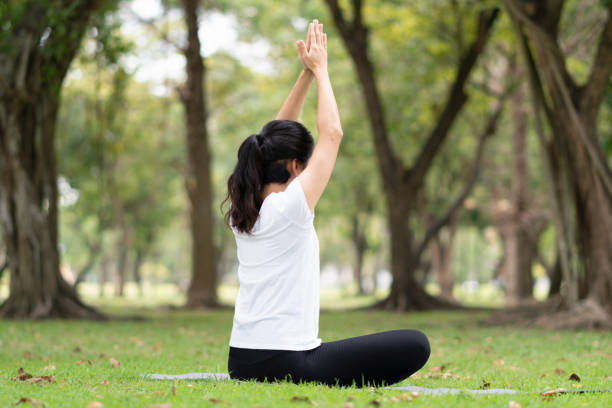 istock Young woman practicing yoga in the park. 1124420219