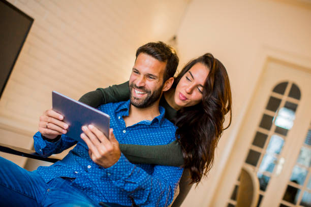 istock Young couple sitting in the living room and using digital tablet 1124420440
