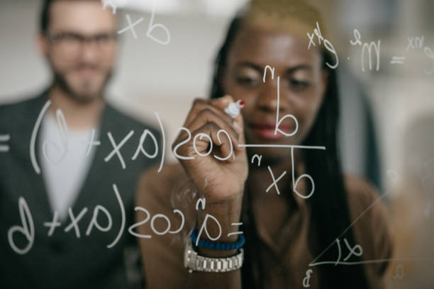 istock Smiling black woman writing MATHS Formulas on a glass 1124420557